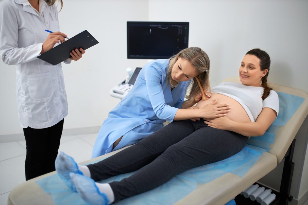 female-gynecologist-checking-pregnant-womans-tummy.jpg